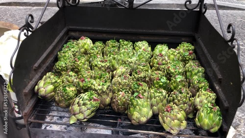 Naples typical street food, roasted artichokes on grill in street of center Naples, Italy