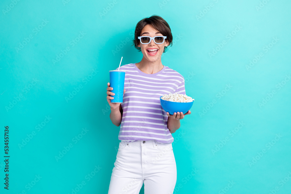 Portrait of positive cheerful excited woman bob hairdo wear striped t-shirt hold blue cup popcorn isolated on turquoise color background Portrait of positive cheerful excited woman bob hairdo wear striped t-shirt hold blue cup popcorn isolated on turquoise color background