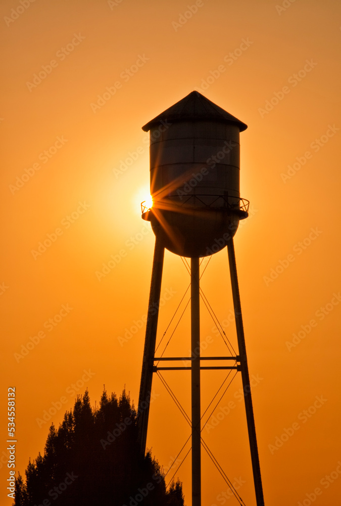 Sun setting behind agricultural water tower. Sun setting behind agricultural water tower.