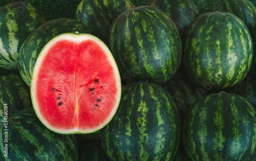 Several large sweet green watermelons and cut watermelons, young green watermelons,