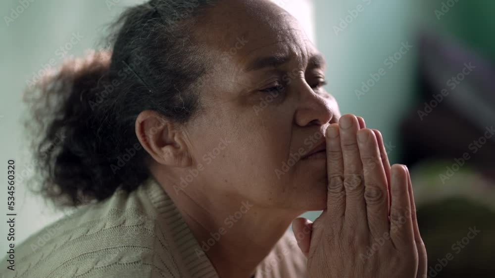 Older woman praying to God at home. One hispanic senior lady in prayer closeup face. Hispanic South American person Older woman praying to God at home. One hispanic senior lady in prayer closeup face. Hispanic South American person