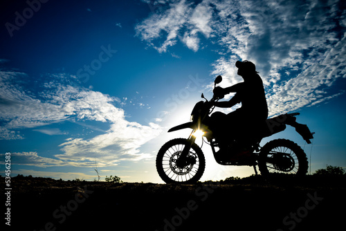 Silhouette Man enjoying a motocross bike on a beautiful evening in the mountains.