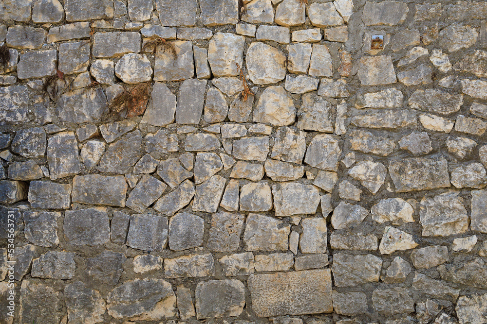 Fototapeta premium Ancient stone wall in the architecture of the old town. Background or backdrop