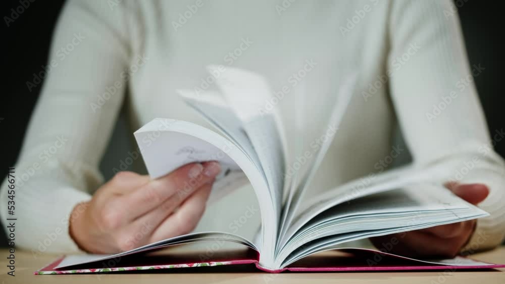 Woman hands Flipping Spanish language book pages, reading and education, Flicking Through Old textbook Close-up, macro shot of paper in university library. Woman hands Flipping Spanish language book pages, reading and education, Flicking Through Old textbook Close-up, macro shot of paper in university library.