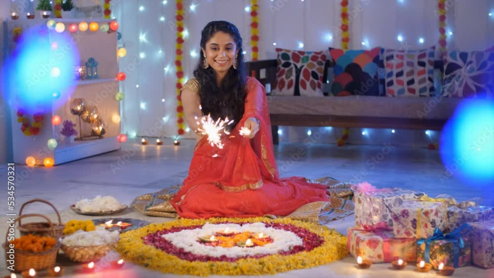 A young woman using Diwali firecrackers Phuljadis at home flower