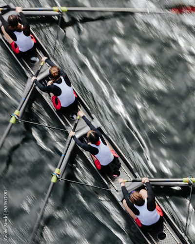 Overhead view of female crew racers rowing in an octuple racing shell, an eights team. photo