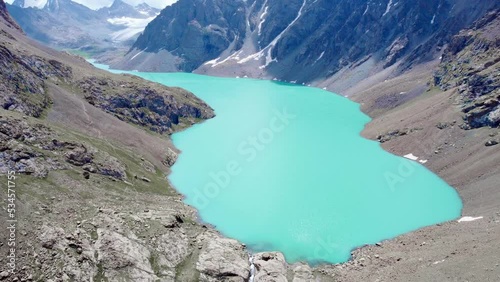 Lake Alakol in the glacial mountains of Kyrgyzstan. Drone flight over a magnificent mountain lake in the mountains of Central Asia photo