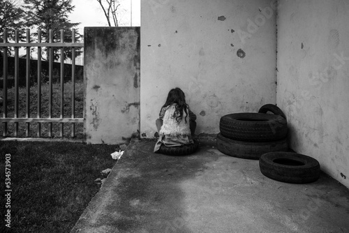 Criança isolada virada para a parede photo