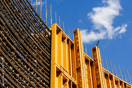 The exterior of a construction site, a high rise building, rebar concrete shuttering and metal mesh grids for building.