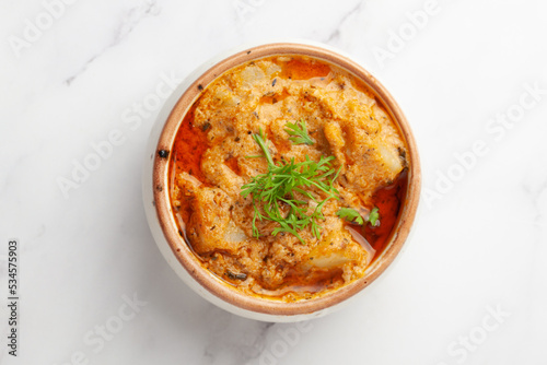 Close-up of Paneer Butter Masala or Cheese Cottage Curry garnished with fresh green coriander leaves in serving a bowl or pan,
