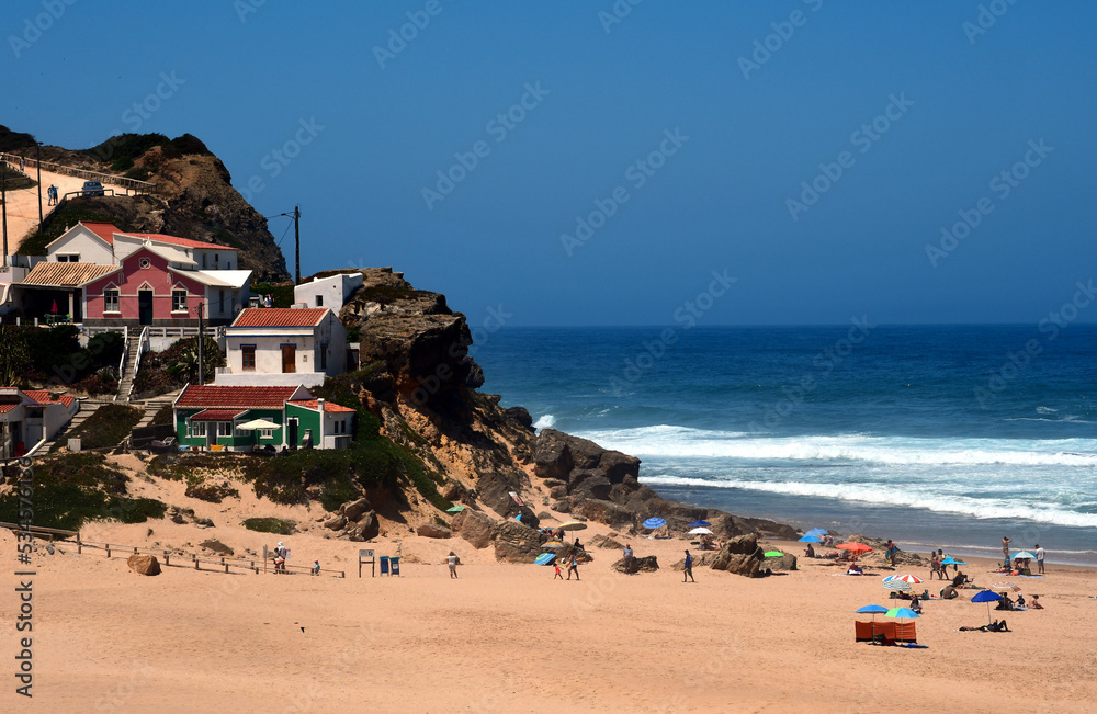 Ein kleines Dorf am Strand mit vielen Touristen und dem Meer im Hintergrund