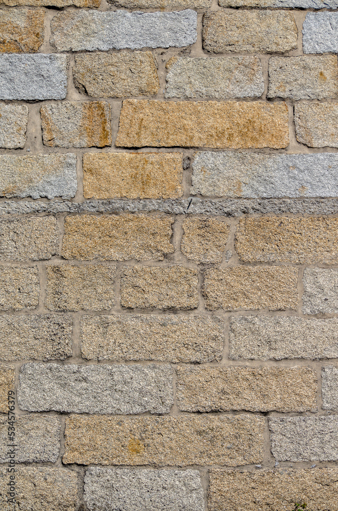 stone wall of regular granite blocks for backgrounds