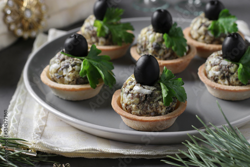 Tartlets with mushrooms, egg and black olives on dark gray background, Close-up