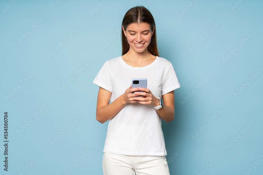 Woman with phone surfing web, chatting online, using dating app isolated on blue background Woman with phone surfing web, chatting online, using dating app isolated on blue background