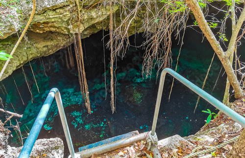 Blue turquoise water limestone cave sinkhole cenote Tajma ha Mexico. photo