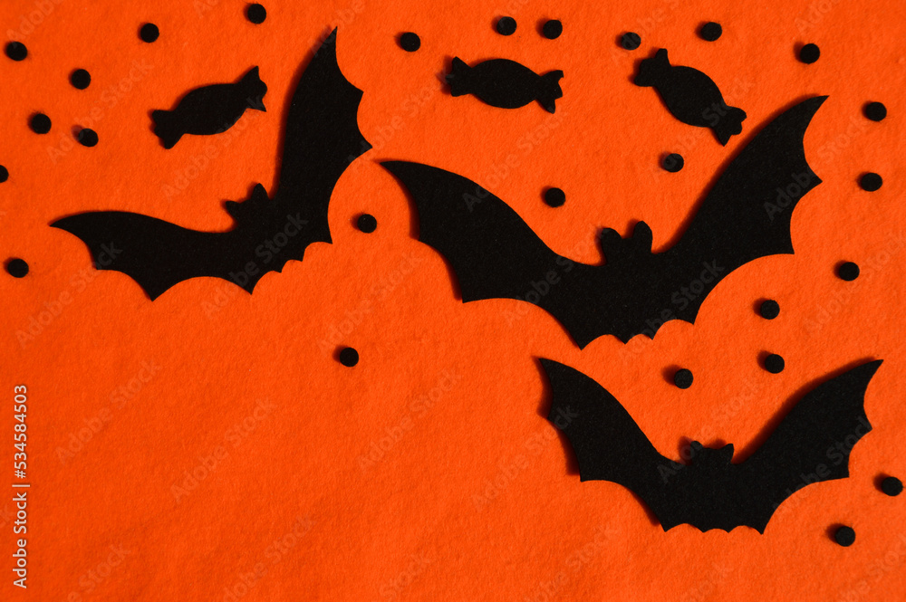 Fototapeta premium preparation for the Halloween holiday. bat made of felt. orange background for the design.