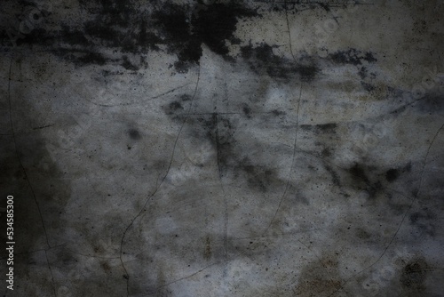 A weathered concrete wall with cracks and peeling paint, showing signs of age and decay.