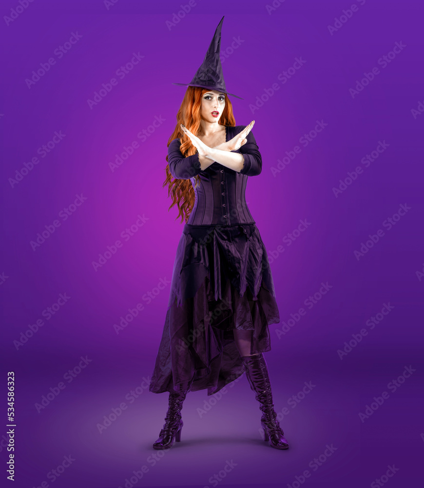 Witch on Halloween gesturing NO, disagreement, refusal. Female wizard fairy character Fantasy gothic red-haired Vampire girl in black dress. Witch on Halloween gesturing NO, disagreement, refusal. Female wizard fairy character Fantasy gothic red-haired Vampire girl in black dress.