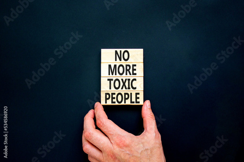 No more toxic people symbol. Concept words No more toxic people on wooden blocks on a beautiful black table black background. Psychologist hand. Business, psychological no more toxic people concept.
