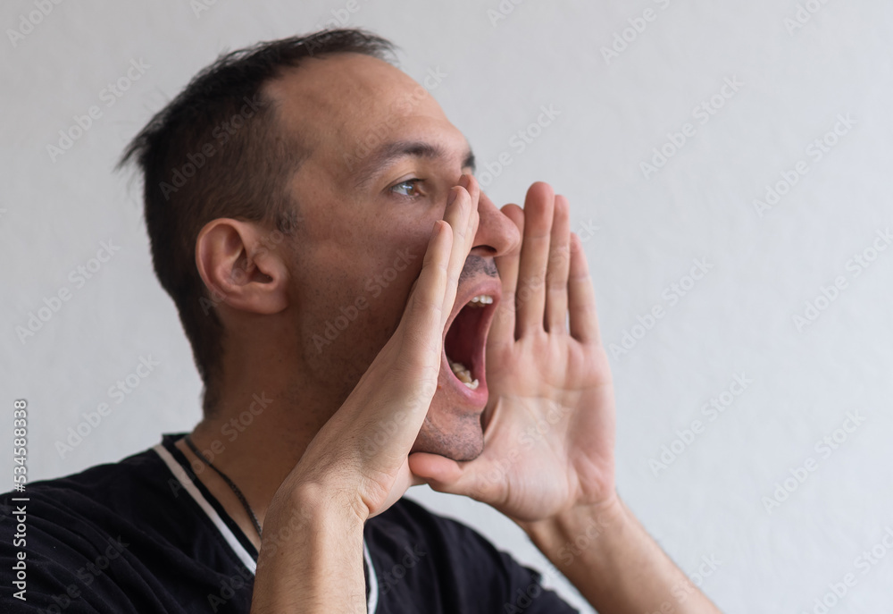 Handsome happy man wearing T-shirt, guy speaking loudly, isolated on white background Handsome happy man wearing T-shirt, guy speaking loudly, isolated on white background