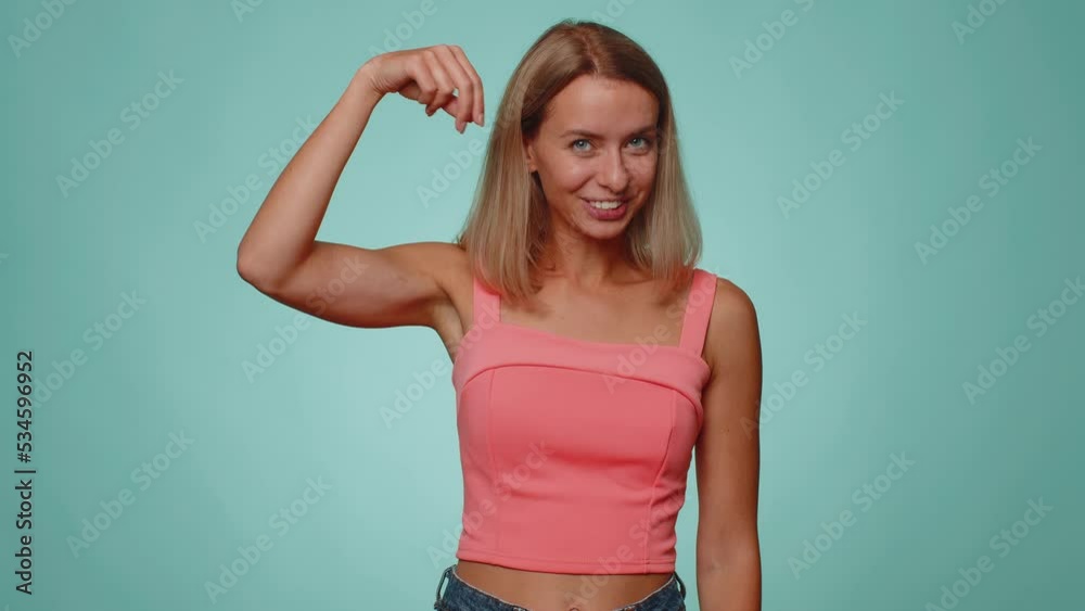 Subscribe. Woman pointing down, saying to look at advertisement, gesturing ok and like, showing place for commercial, promotional information below. Young girl isolated on blue studio wall background Subscribe. Woman pointing down, saying to look at advertisement, gesturing ok and like, showing place for commercial, promotional information below. Young girl isolated on blue studio wall background