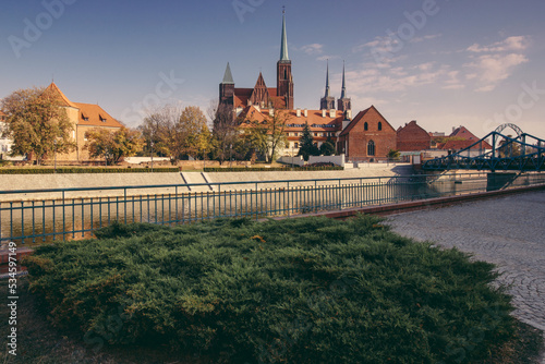 View  of medieval town: Tumski Bridge between the islands of Wyspa Piasek and Ostrow Tumski and Roman Catholic Church of St. NMP in autumn. Poland, Wroclaw. photo
