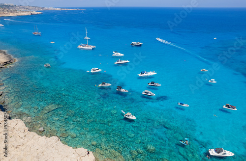 Drone aerial seascape with luxury yachts moored in the coast and unrecognised people swimming and relaxing. Summer vacations in the sea. Ayia Napa Cyprus