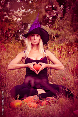 Woman in witch costume sitting in lotus pose