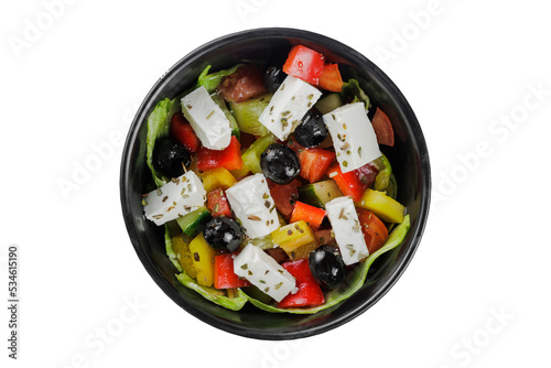 Greek salad with tomato and fresh vegetables in black bowl on isolated on the white background. Top view