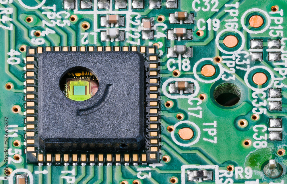 Green silicon die and gold wires inside round hole of integrated circuit. Close-up of optoelectronic sensor on PCB of optical laser computer mouse with surface mount assembly of electronic components. - obrazy, fototapety, plakaty 