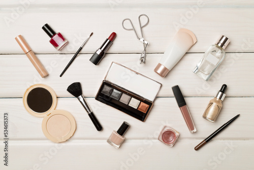 Different makeup products on wooden background, top view