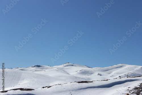 Beautiful landscape of mountains covered with white snow and clear blue sky in the background 