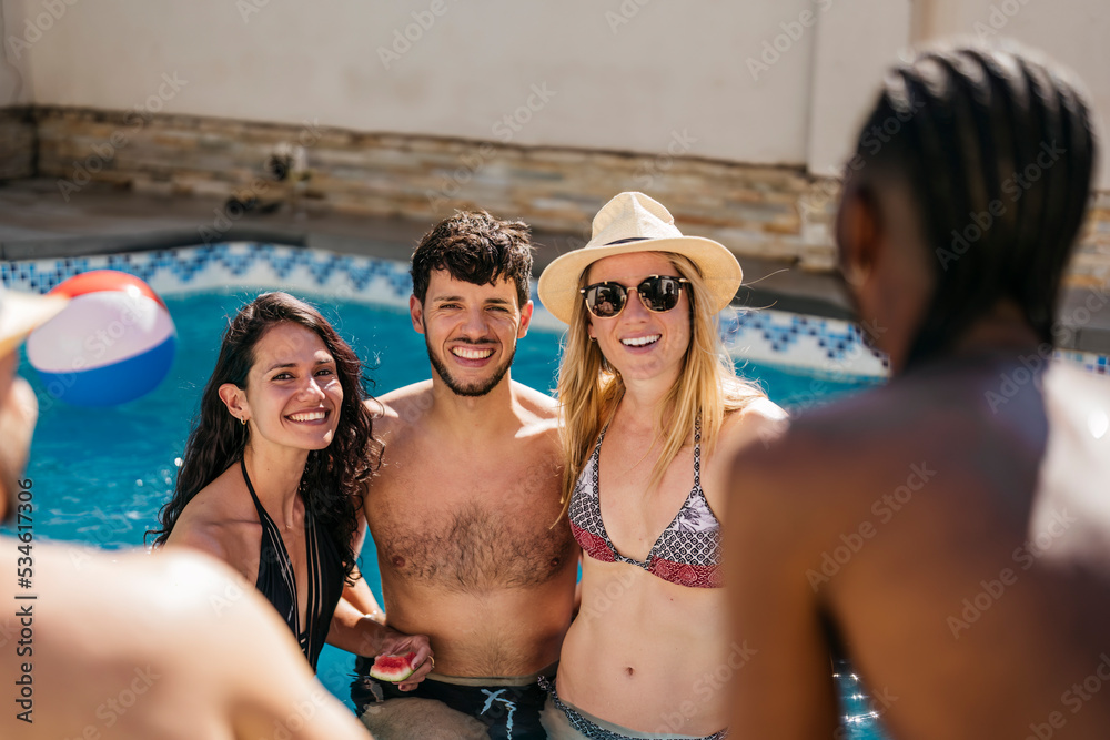 portrait of young latin man with 2 women inside a swimming pool