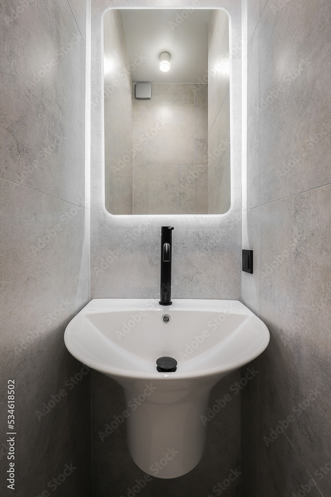 Fototapeta premium Faucet with ceramic sink with mirror in the bathroom