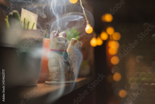 Gatito que mueve la patita con humo de sahumerio y luces photo