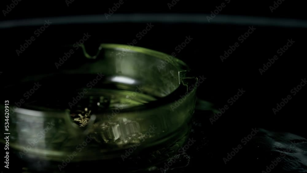 Lit cigarette burning in ashtray close up. Lit cigarette burning in ashtray close up.
