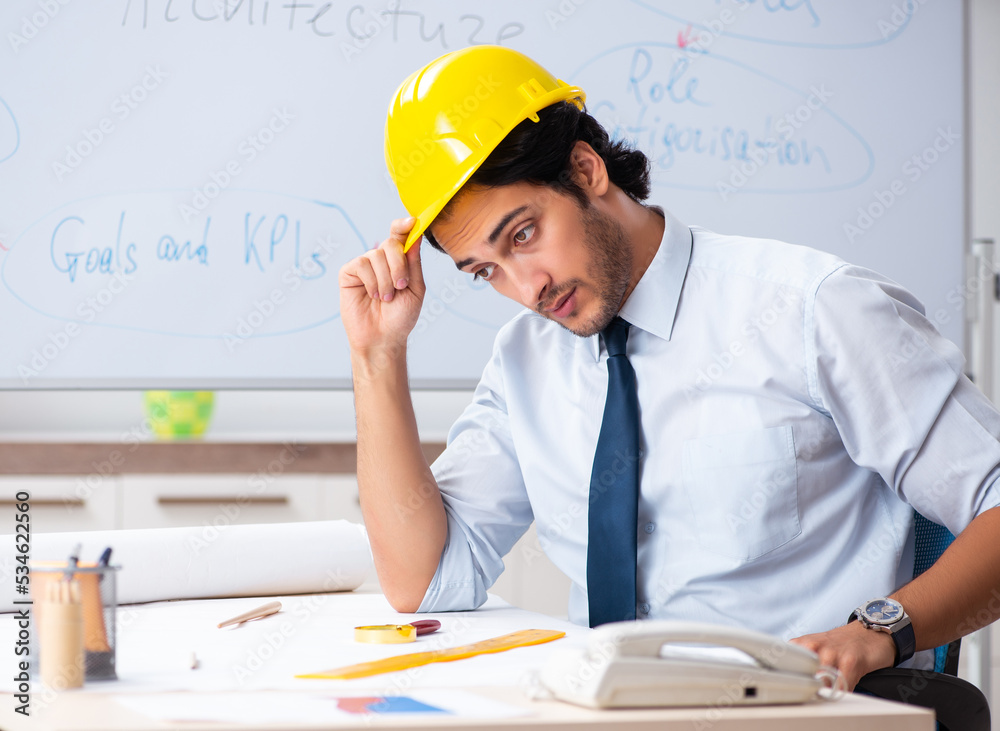 Young male architect in front of the whiteboard Young male architect in front of the whiteboard