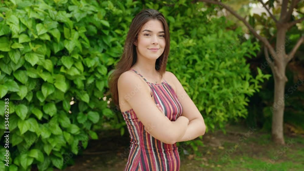 Young beautiful hispanic woman standing with arms crossed gesture at park Young beautiful hispanic woman standing with arms crossed gesture at park