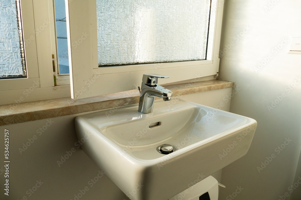 Wasserhahn am Waschbecken falsch montiert, Fenster lässt sich nicht mehr öffnen - obrazy, fototapety, plakaty 