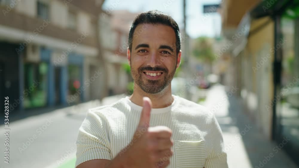 Young hispanic man smiling confident doing ok sign with thumb up at street Young hispanic man smiling confident doing ok sign with thumb up at street