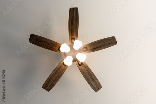 Residential ceiling fan in motion on a white ceiling. photo
