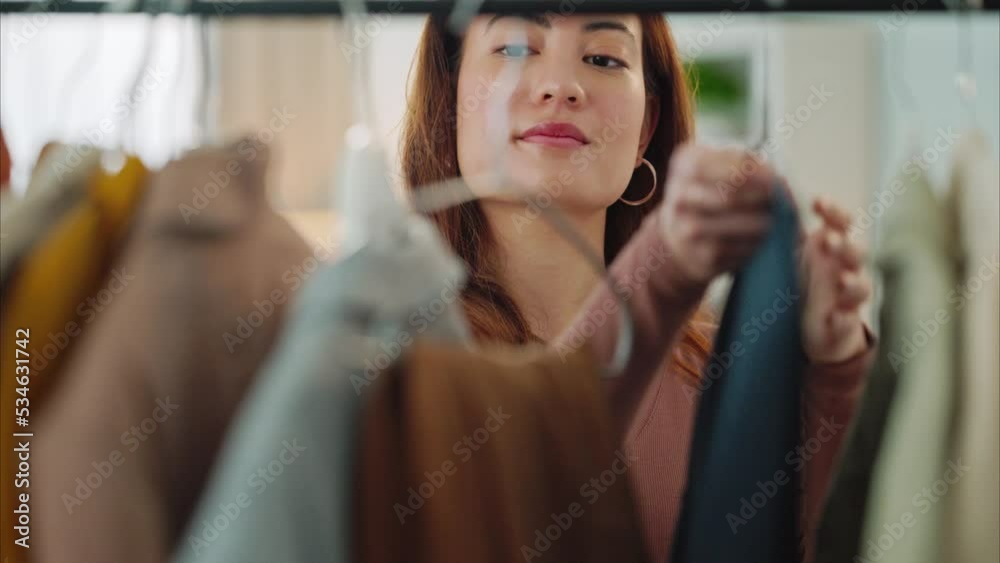 A woman customer shopping for luxury, fashion clothing and looking at designer clothes. Women love a boutique retail store, with a modern shopping mall and an expensive cotton shirt on the sales rack