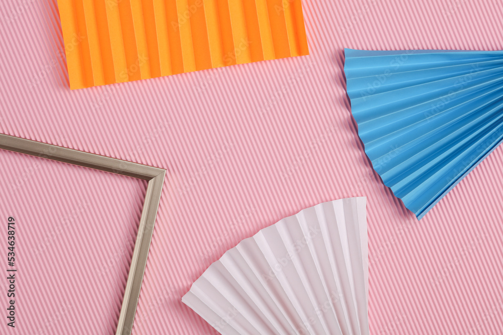 Gold frame with paper fans on a pink background. Abstract geometric background Gold frame with paper fans on a pink background. Abstract geometric background