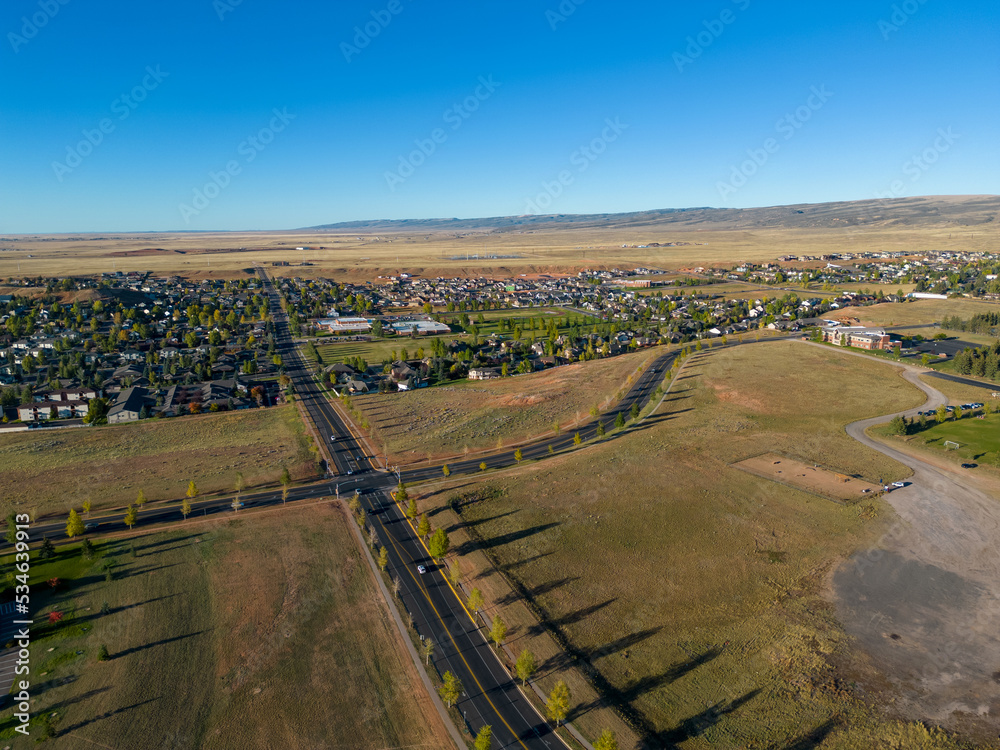 Car traffic intersection with stop lights roads in rural Fall Wyoming from 4k Aerial drone dji mini 3 pro with town in the background