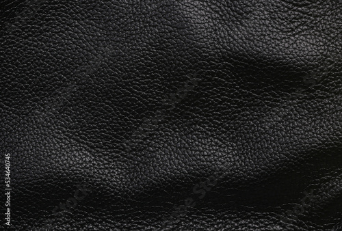 Texture of wavy black leather surface closeup