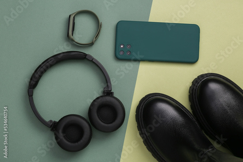 Leather shoes and modern gadgets on a green background. Top view