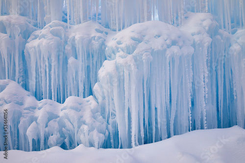 Icicles covered with snow in a wall of blue ice on a beautiful winter day © Jill Greer
