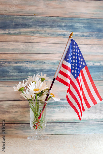 American flag and vase of daisies makes a patriotic rustic still life