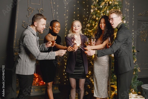 Male and female friends in elegant dresses celebrating New Year