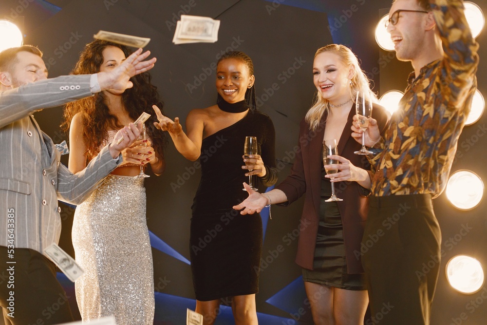 Male and female friends in elegant dresses celebrating New Year